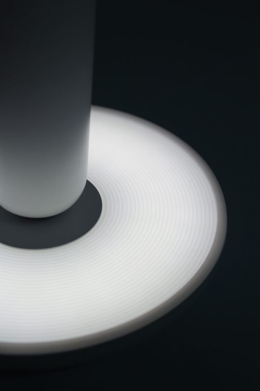 Een detail van de onderkant van een minimale bureaulamp in het wit, verkocht door Vibrant LED Lights